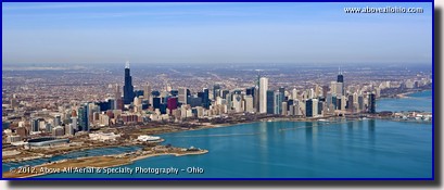 An aerial panoramic photo of the Chicago, IL, skyline; looking west over Lake Michigan towards downtown.