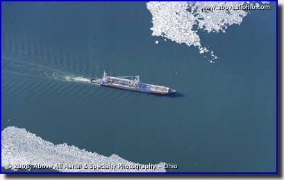 A freighter on Lake Erie passes between some clumps of ice