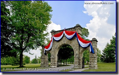 An architectural photograph of the entrance to a cemetery decorated for Memorial Day; Medina, Ohio