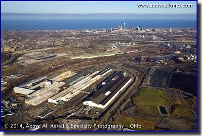 A somewhat low level oblique view of some of Cleveland's many steel mills with downtown Cleveland in the background.