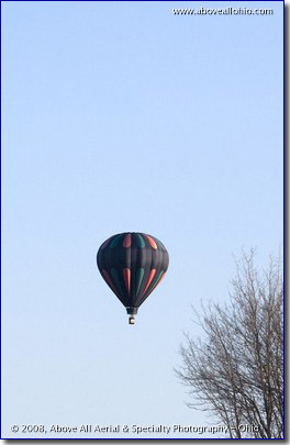A colorful hot air ballon floating in a blue sky
