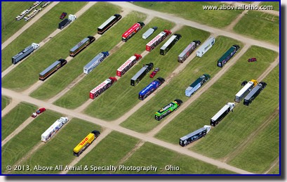 An aerial view of IndyCar team transporters lined up waiting to get into the paddock area at the Mid-Ohio Sports Car Course in Lexington, OH.