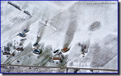 An aerial view of snowy fields showing how the wind is affected by buildings and trees.
